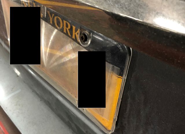 A photo showing the cloudy, semi clear plastic cover over the license plate